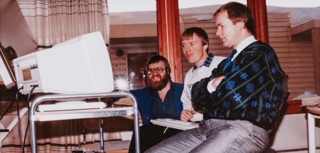 Tres señores enfrente de un ordenador antiguo