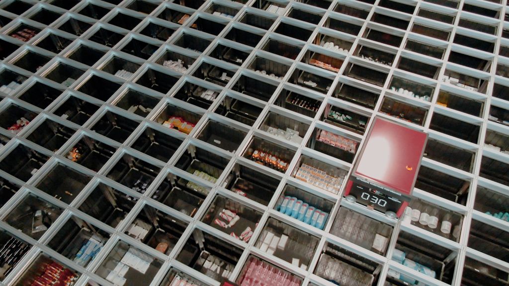 Imagen detalle desde arriba de un almacén AutoStore con las cubetas llenas de artículos y un robot