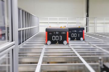 Dos robots AutoStore de Element Logic desplazándose por encima de la rejilla de aluminio de este sistema de automatización del almacén