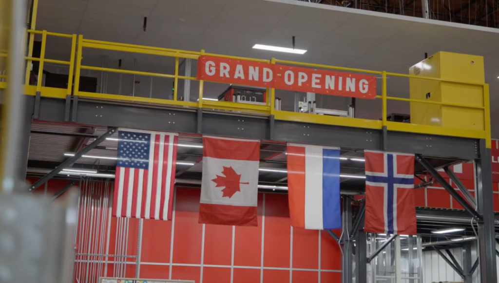 Gran inauguración en el almacén de Helly Hansen con banderas de EE. UU., Canadá y Noruega colgadas.